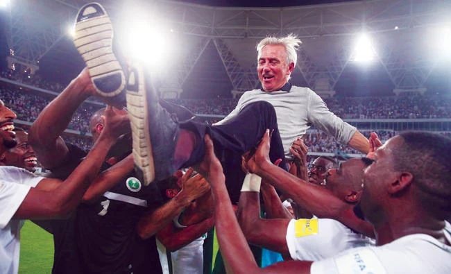 The Saudi players lifted Bert Van Marwijk triumphantly in the air after he secured their place at next year’s World Cup. (AP)
