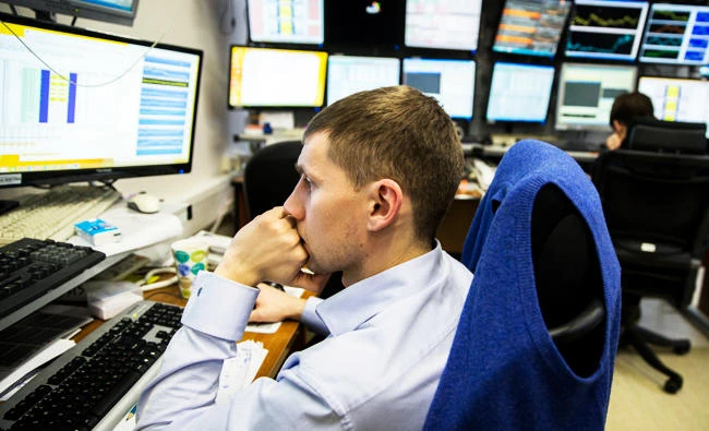 A bank trader works in an operation room at Metallinvestbank in Moscow, Russia, Friday, Jan. 16, 2015. Russian markets are trading sluggishly as the country braces for the possibility that its credit rating may be downgraded to "junk" level later Friday for the first time in a decade. (AP Photo/Pavel Golovkin)