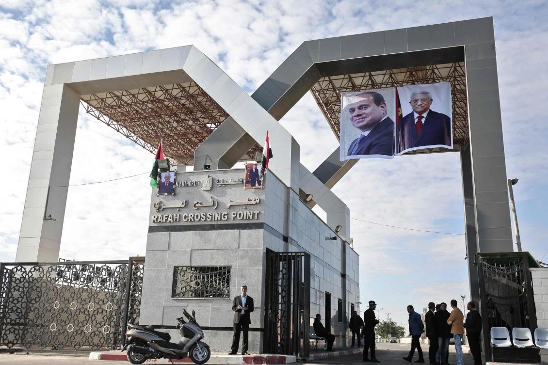 Portraits of Egyptian President Abdel Fattah El-Sisi and Palestinian leader Mahmud Abbas hang at the Rafah border crossing with Egypt on Nov. 1, 2017. Hamas handed over control of the Gaza Strip’s border with Egypt to the Palestinian Authority today, a first key test of a Palestinian reconciliation agreement agreed last month. (AFP/Said Khatib)