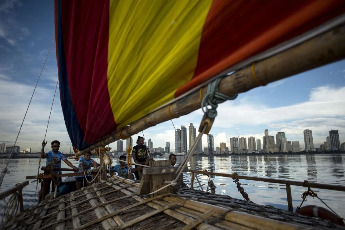 Above, the traditional Philippine wooden boat known as balangay sailing on their craft in Manila Bay, which Filipino adventurer Carina Dayondon is set to sail to China. (AFP)