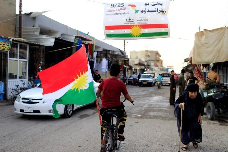 A boy rides a bicycle with the flag of Kurdistan in Tuz Khurmato, Iraq September 24, 2017. (REUTERS)