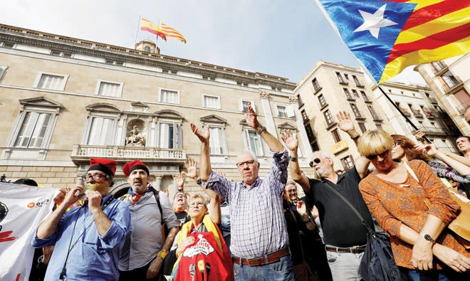 People gather at Sant Jaume square to demand the freedom of the leaders of two of the largest Catalan separatist organizations, Catalan National Assembly's Jordi Sanchez and Omnium's Jordi Cuixart, who were jailed by Spain's High Court, in Barcelona Thursday. (Reuters)