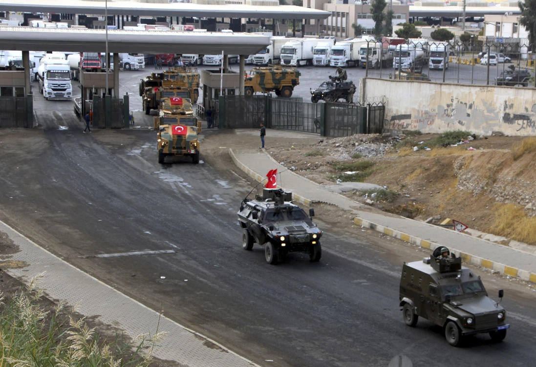 Above, a convoy of Turkish army vehicles are drive way from the Habur/Ibrahim Khalil border crossing with Iraq, near Silopi in southeastern Turkey on October 31. (DHA-Depo Photos via AP)
