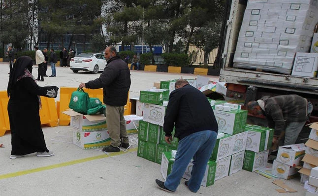 Syrian refugees collect their share of relief goods from volunteers of the King Salman Humanitarian Aid and Relief Center (KSRelief) at a refugee center in Jordan. (SPA file photo)