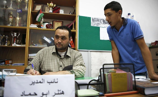 Palestinian Hitler Abu Hamad, deputy head at a school, works at his office in the Israeli occupied city of Hebron, on September 26, 2017. (AFP / HAZEM BADER)