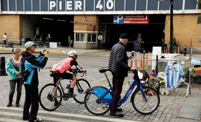 Pedestrians and bicyclists stop to photograph a memorial on West Street two days after a man driving a rented pickup truck mowed down pedestrians and cyclists on a bike path alongside the Hudson River, in New York, U.S., on Thursday. (REUTERS)