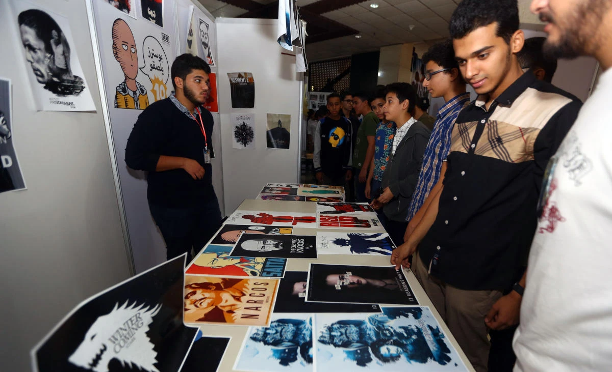 Libyans gather at a stall selling posters the Libya Comic Convention in Tripoli on November 2. Members from the Deterrence Force — a group of mainly conservative Islamists that acts as the police for the UN-backed government — entered the venue, seized computers and arrested organizers. (AFP)