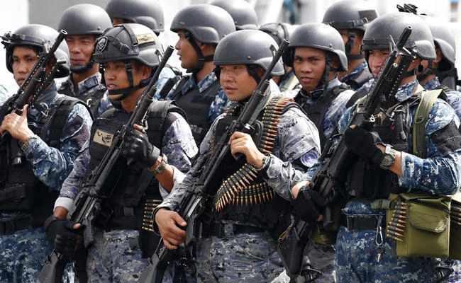 An armed unit of the Philippine Coast Guard, who have been deployed in Marawi in southern Philippines to augment government troops in its fight against Muslim militants, stand at attention as they are welcomed upon docking at Manila's South Harbor on Nov. 3, 2017 in Manila. Government forces are now on high alert in the national capital for the ASEAN summit. (AP Photo/Bullit Marquez)