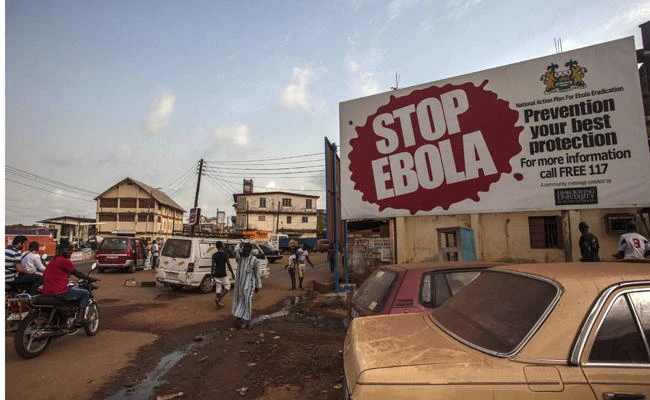 People pass a banner reading 'STOP EBOLA' forming part of Sierra Leone's Ebola free campaign in the city of Freetown, Sierra Leone, in this Jan. 15, 2016 file photo. (AP Photo/Aurelie Marrier d'Unienville, file)