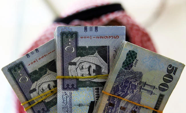 A Saudi money changer displays Saudi Riyal banknotes at a currency exchange shop in Riyadh, Saudi Arabia, in this September 29, 2016 file photo. (REUTERS)