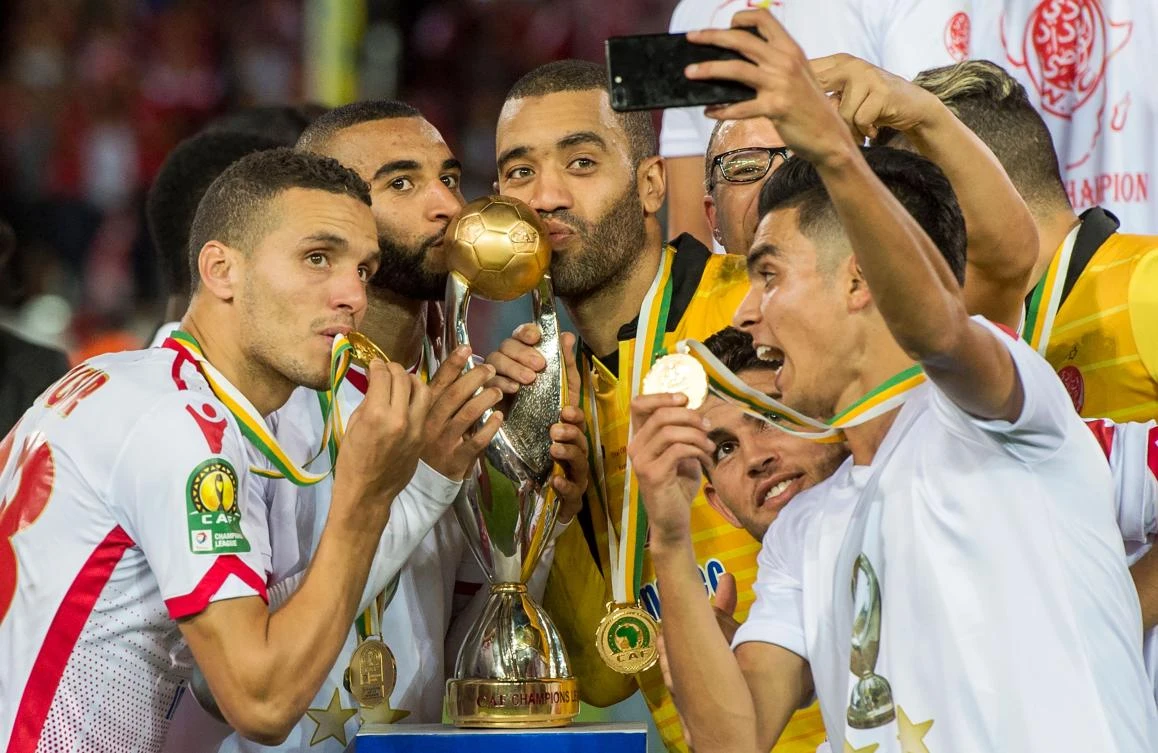 Wydad Casablanca's players celebrate with their trophy after winning the CAF Champions League final against Egypt's Al-Ahly on November 4, 2017, at Mohamed V Stadium in Casablanca. (AFP)