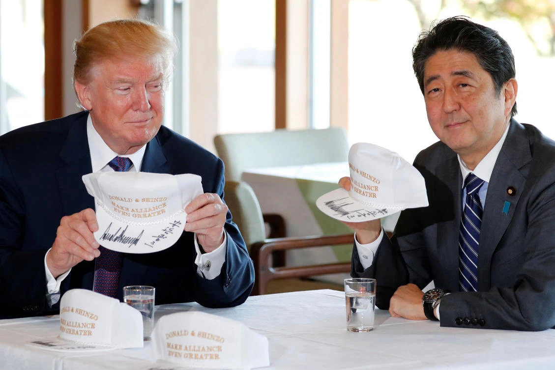 US President Donald Trump and Japan’s Prime Minister Shinzo Abe hold hats they signed, reading “Donald & Shinzo Make Alliance Even Greater” before lunch and a round of golf at Kasumigaseki Country Club in Kawagoe. (Reuters)