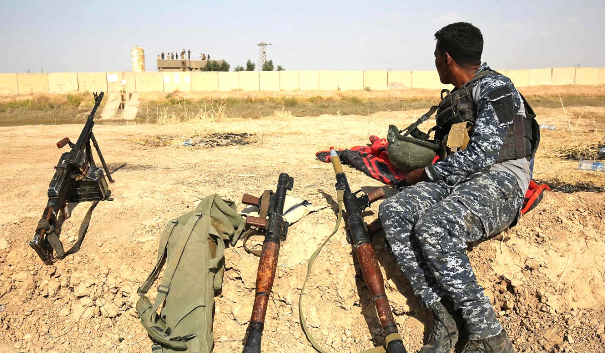 A member of the Iraqi forces sits on a river bank across from Kurdish peshmerga positions on the outskirts of Kirkuk in this file photo. (AFP)