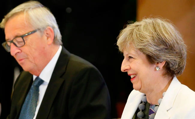 This file photo taken on October 20, 2017 shows European Commission President Jean-Claude Juncker sitting next to Britain's Prime Minister Theresa May as they attend the second day of the European Council Meeting in Brussels. (AFP)