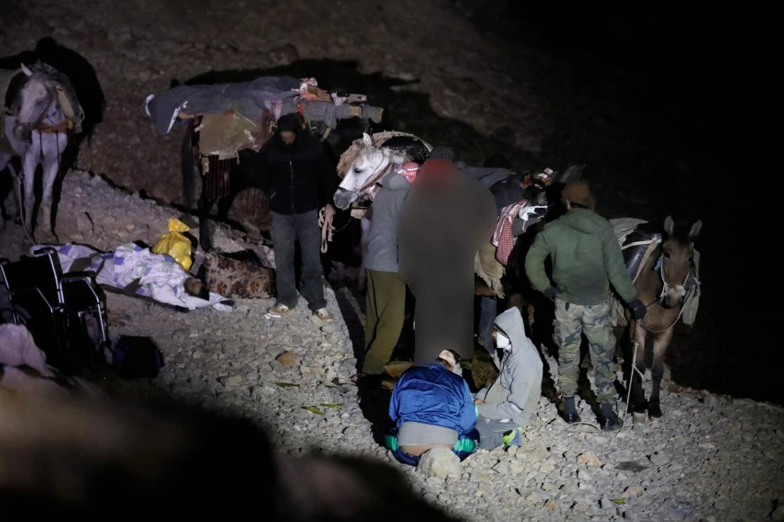 A picture taken on Oct. 26, 2017 shows wounded Syrian men sitting next to their mules after approaching a meeting point with Israeli soldiers on Mount Hermon in the Israeli-annexed Golan Heights on the border line between Israel and Syria, before being transfer to an Israeli hospital for medical treatment. (The faces are blurred due to Israeli Army censorship) (AFP/Menahem Kahana)