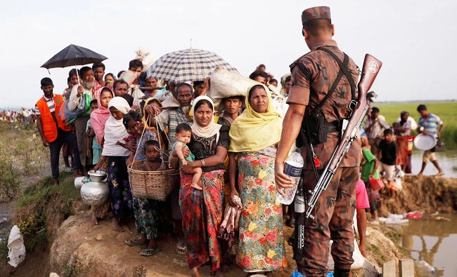 A Border Guard Bangladesh (BGB) asks Rohingya refugees to come in a queue as they continue their journey to camp after crossing the Naf river at the Bangladesh-Myanmar border in Palang Khali, near Cox's Bazar, Bangladesh, in this November 2, 2017 photo. (REUTERS)