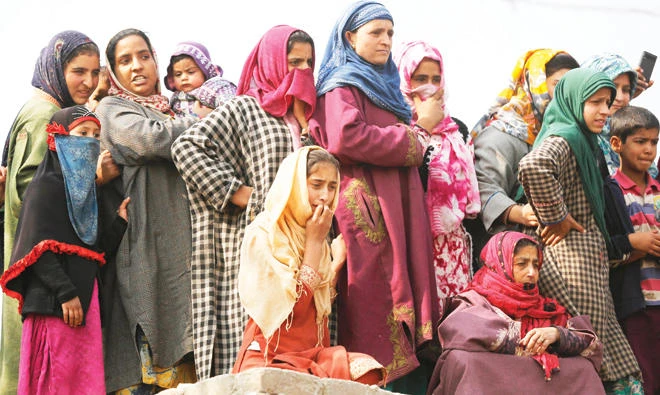 Kashmiri women watch as villagers carry the body of militant Waseem Ahmad during his funeral procession in Drubgam, 48 km south of Srinagar, on Tuesday. (AP)