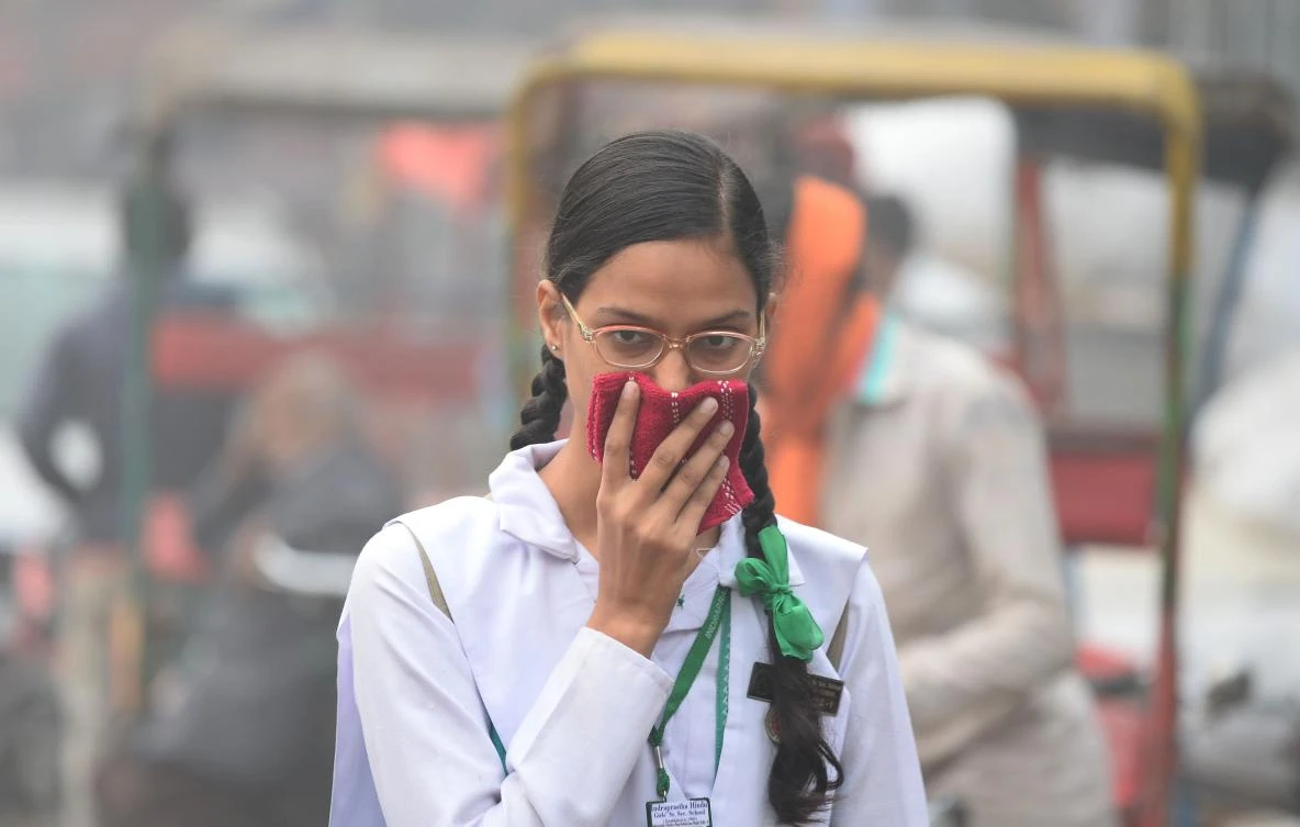 An Indian schoolgirl covers her face with a handkerchief amid heavy smog in the old quarters of New Delhi on Nov. 8, 2017. (AFP/Sajjad Hussain)
