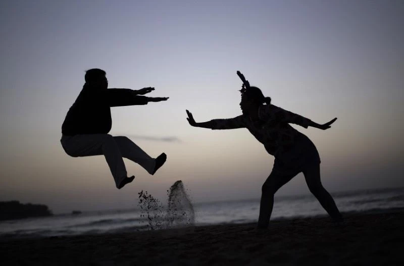 A couple acts out a martial-arts move for a friend’s camera (not pictured) as they wait to welcome the first sunrise of 2015 on Sydney’s Bondi beach at dawn on January 1, 2015. (File photo by Reuters)