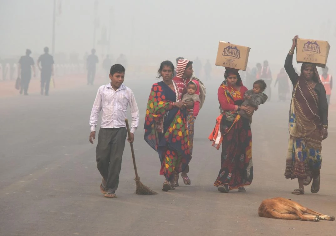 Residents walk along a road amid heavy smog in New Delhi. The Indian capital declared a pollution emergency and banned the entry of trucks and construction activity. (AFP)