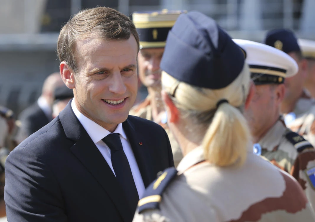 French President Emmanuel Macron shakes hands with military personnel, deployed to fight Daesh, at a UAE naval base during his second day of visit in the Gulf country. (AP)