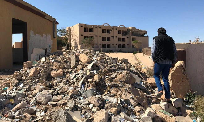 A Libyan man walks toward a damaged hotel in the city of Bani Walid, Libya. It was hit during the NATO-backed campaign in 2011. (Reuters)
