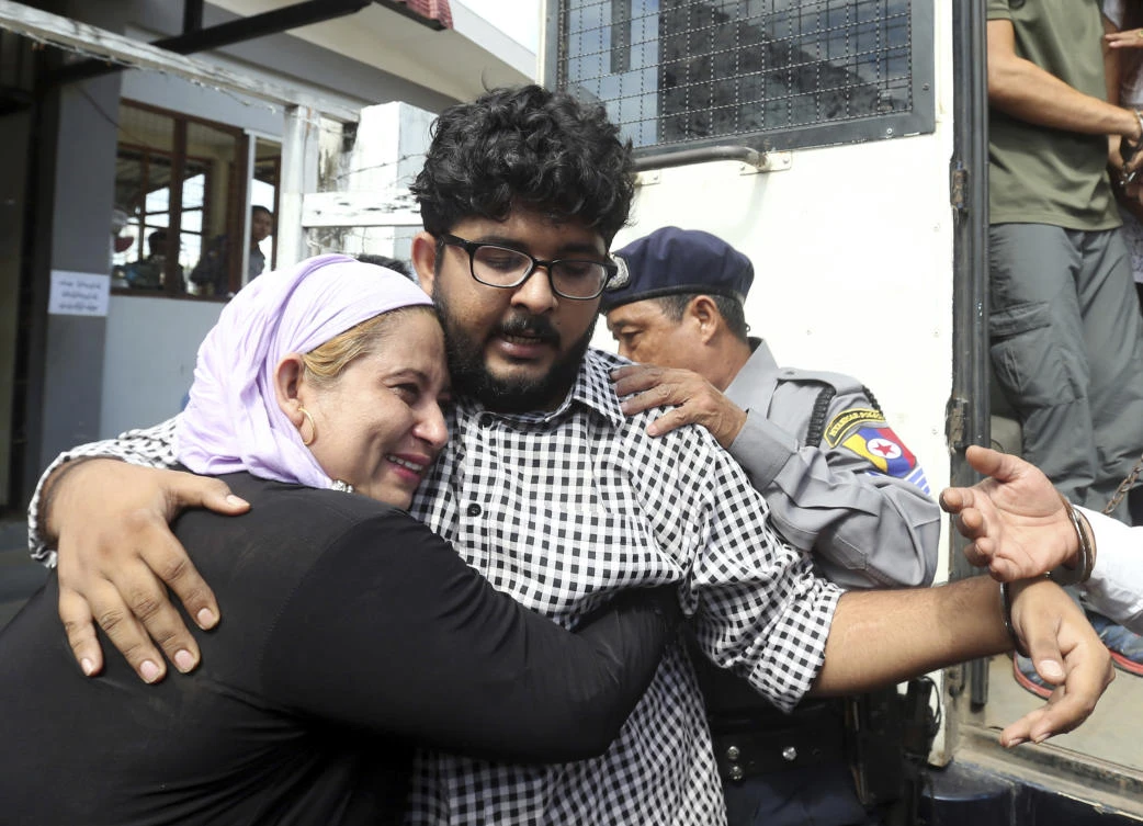 Aung Naing Soe, a Burmese freelance journalist and interpreter, is hugged by his mother during his first court appearance together with three others after being accused for allegedly flying drones illegally over parliament buildings in Naypyitaw. (AP)