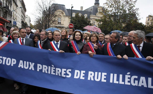Clichy la Garenne's mayor Remi Muzueau, center left, leads the demonstration against Muslim street prayers, in the Paris suburb of Clichy la Garenne, on Friday, Nov. 10, 2017. (AP Photo/Thibault Camus)