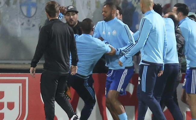 Marseille's Patrice Evra, third left, raises his foot trying to kick a man during a scuffle with Marseille supporters who trespassed into the field before the Europa League group I soccer match between Vitoria SC and Olympique de Marseille at the D. Afonso Henriques stadium in Guimaraes, Portugal, on Nov. 2, 2017. (AP Photo/Luis Vieira)