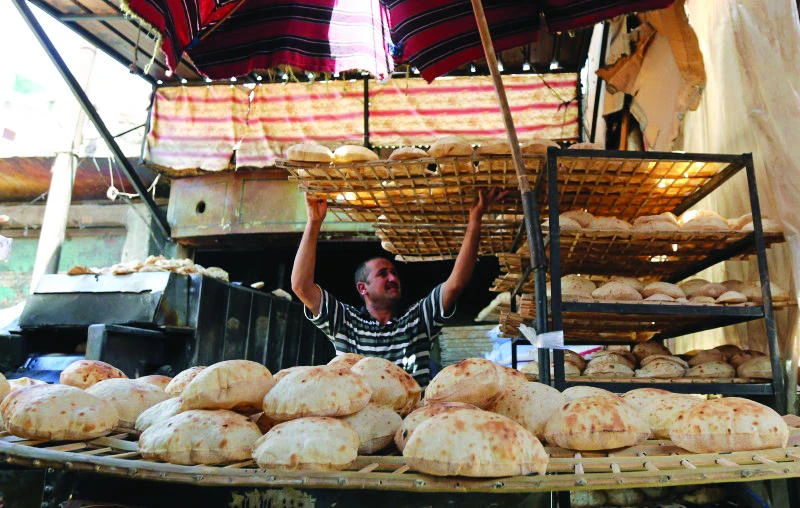 An Egyptian baker is seen beside a vegetable market in Cairo, Egypt. (Reuters)
