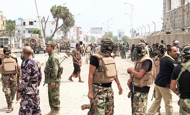 Yemeni men and security forces inspect the site of a suicide bombing in the southern port city of Aden, in this November 5, 2017 photo. (AFP)