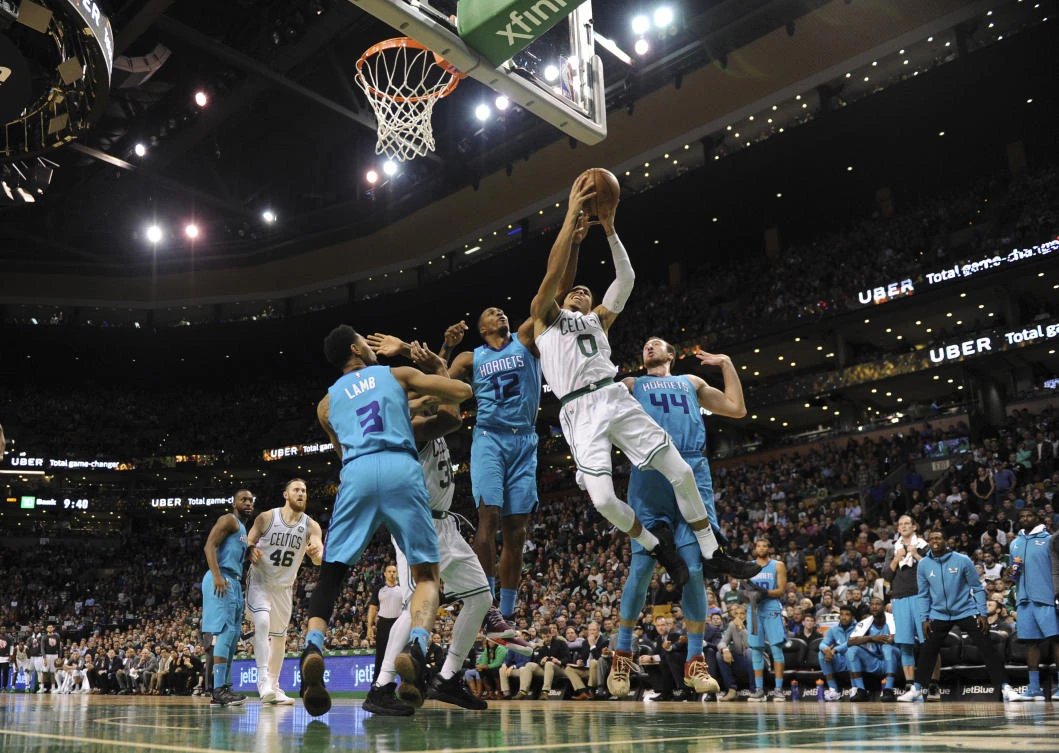 Above, Boston Celtics forward Jayson Tatum is fouled by Charlotte Hornets center Dwight Howard while driving to the basket. The Celtics team extended their winning streak to 11 games. (USA TODAY Sports)