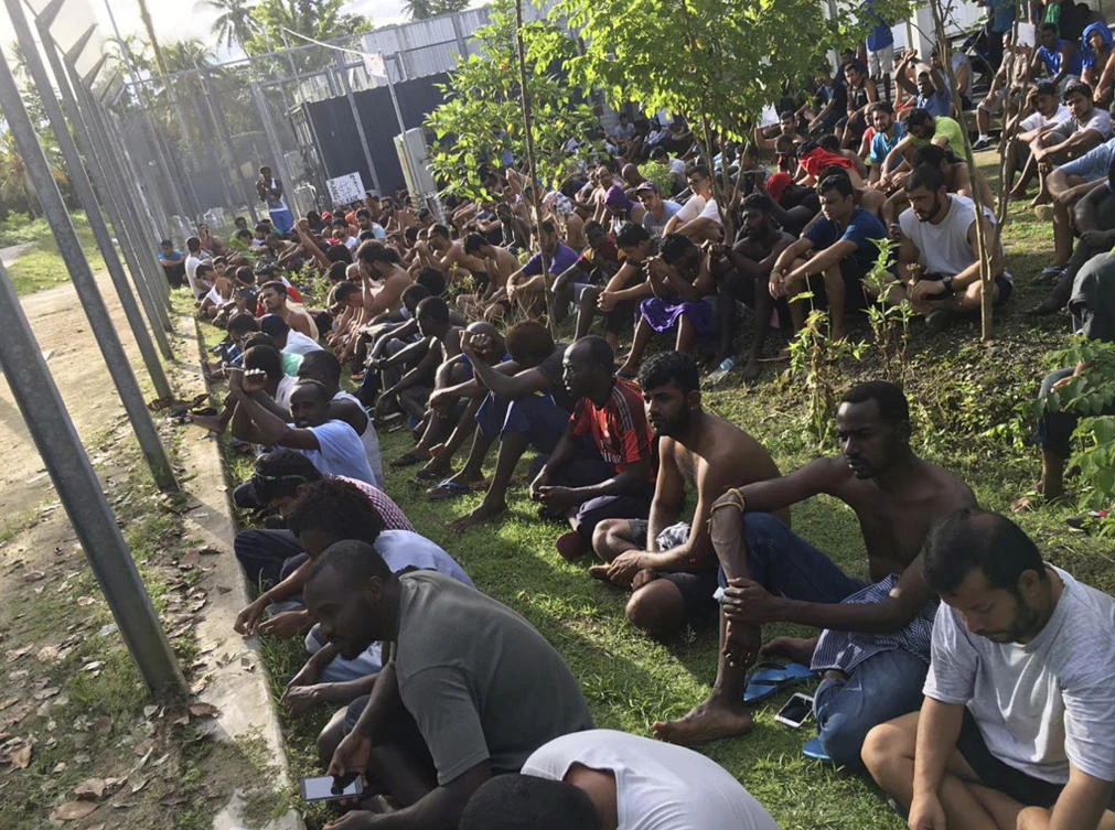 In this Thursday, Nov. 9, 2017 image supplied by Hass Hassaballa, asylum seekers sit on the ground as they refuse to leave the Manus Island detention center in Papua New Guinea. An Australian minister on Friday, Nov. 10 predicted a conflict between Papua New Guinea police and hundreds of asylum seekers who have refused to leave a decommissioned immigration camp where many hold out hope of resettling in the United States. (AP)