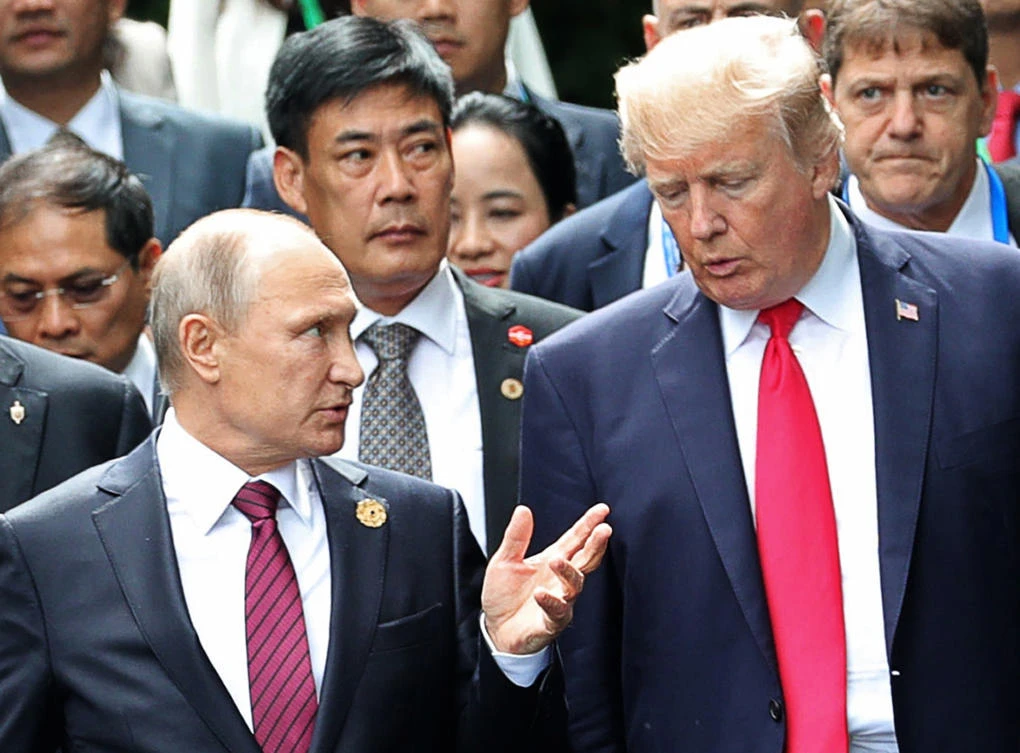 US President Donald Trump, right, and Russia’s President Vladimir Putin talk while on their way to a family photo session at the APEC Summit in Danang, Vietnam on Saturday, November 11. (Kremlin pool photo via AP)