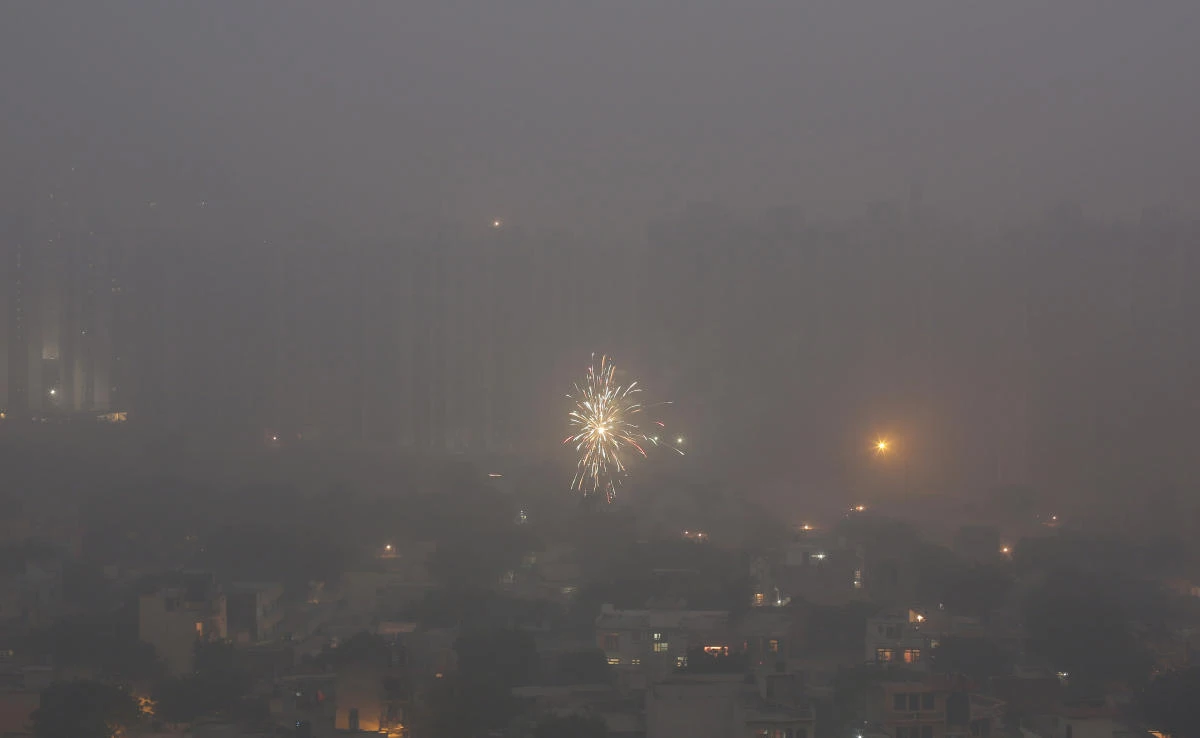 Residential buildings are enveloped in a blanket of smog as a firecracker lights up on the outskirts of New Delhi, India, Saturday on November 11, 2017. (AP)