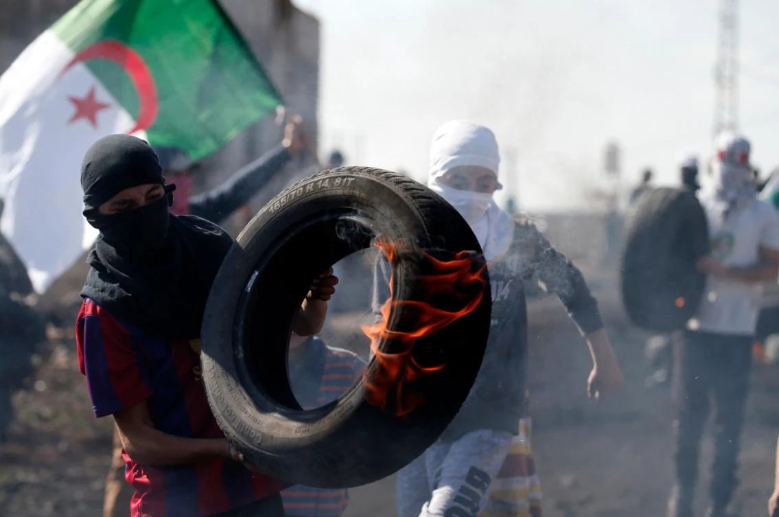 Above, a Palestinian protester carries a burning tire during clashes with Israeli forces following a weekly demonstration against the expropriation of Palestinian land by Israel in the village of Kfar Qaddum, near Nablus in the occupied West Bank. (AFP)