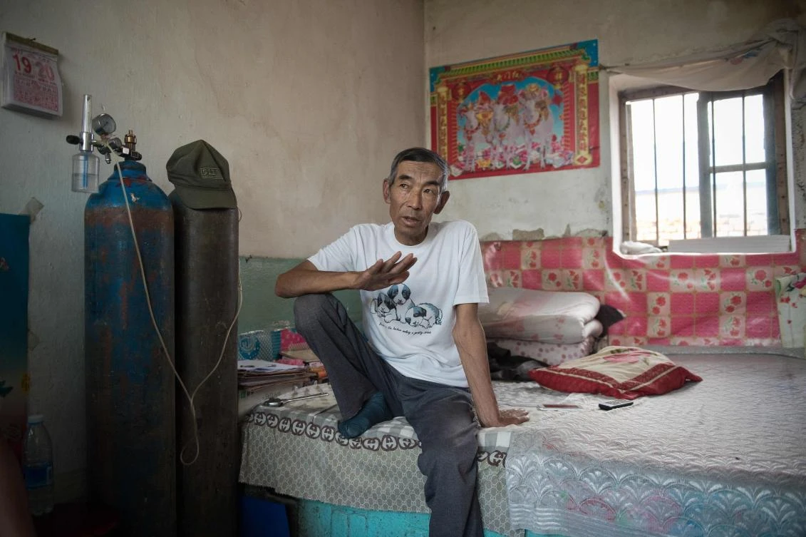 Farmer Wang Enlin sits in his room inside his house in Yushutun. The 64-year-old is determined to reap justice as he readies for a fresh battle in his war with a subsidiary of China’s largest chemical firm, which he accuses of polluting and destroying his farmland. (AFP)