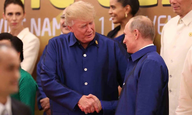 US President Donald Trump (L) shakes hands with Russia's President Vladimir Putin (R) as they pose for a group photo ahead of the Asia-Pacific Economic Cooperation (APEC) Summit leaders gala dinner in the central Vietnamese city of Danang on November 10, 2017. (AFP)
