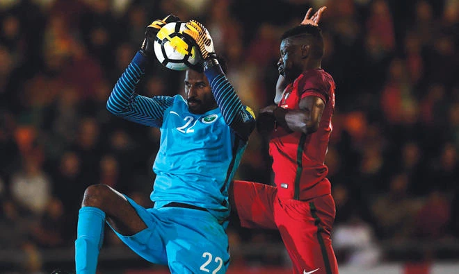Mohammed Al-Owais rises highest to collect a ball against Portugal on Friday night. (AFP)