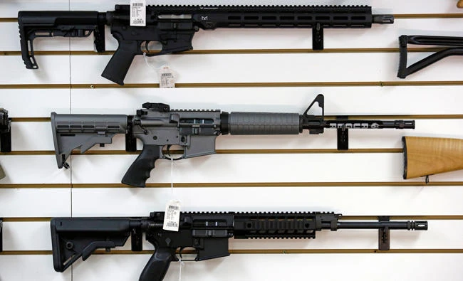 A Ruger AR-15 semi-automatic rifle, center, the same model, though in gray rather than black, used by the shooter in a Texas church massacre two days earlier, sits on display with other rifles on a wall in a gun shop, in this Nov. 7, 2017 photo, in Lynnwood, Wash. (AP)