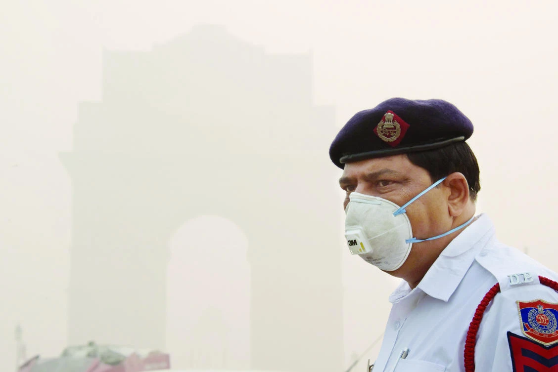 An Indian policeman wearing a protection mask as he works near India Gate amid heavy smog in New Delhi on Thursday. (AFP)