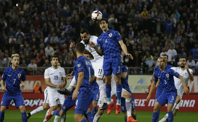 Croatia's Sime Vrsaljko, center, jumps for a high ball with Greece's Kostas Mitroglou during the World Cup qualifying play-off second leg soccer match between Greece and Croatia at Georgios Karaiskakis stadium, in Piraeus port, near Athens, on Sunday, Nov. 12, 2017. (AP Photo/Thanassis Stavrakis)