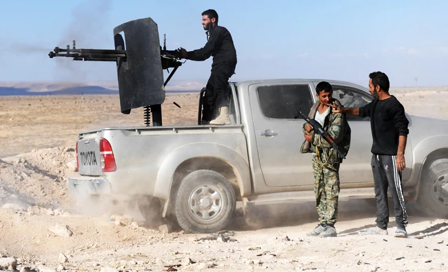 A member of the Syrian pro-regime forces fires a heavy machine gun mounted on the back of a pickup truck, during the advance towards rebel-held positions west of Aleppo, near Abu al-Zuhur military airport in the Idlib province countryside, on Saturday. (AFP)