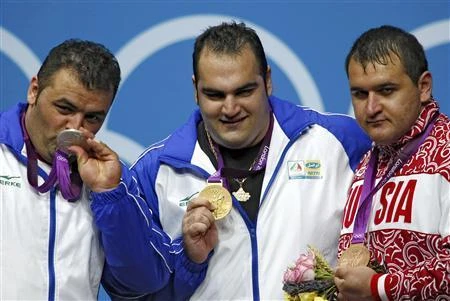 Iran’s Sajjad Anoushiravani Hamlabad, left, Iran’s Behdad Salimikordasiabi, center, and Russia’s Ruslan Albegov pose with their silver, gold and bronze medals at the ExCel venue during the London 2012 Olympic Games on August 7, 2012. (File photo by Reuters)