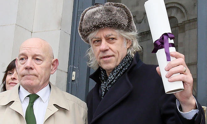 Irish musician Bob Geldof, right, holds aloft his Freedom of the City of Dublin scroll as he prepares to return it at Dublin City Hall, in Dublin, on Monday. (AFP)