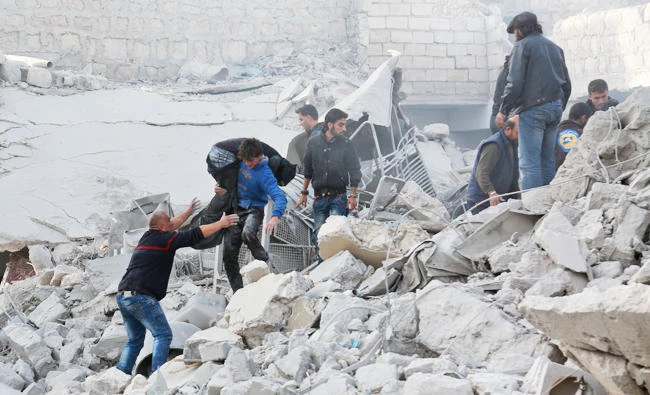Syrians dig through the debris of a building as they search for survivors following a reported airstrike on the rebel-held town of Atareb in Syria's northern Aleppo province on Monday. (AFP)
