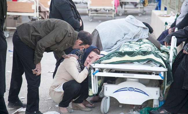 Iranians mourn over the body of a victim following a 7.3-magnitude earthquake in Sarpol-e Zahab in Iran's western province of Kermanshah on Monday. (AFP)