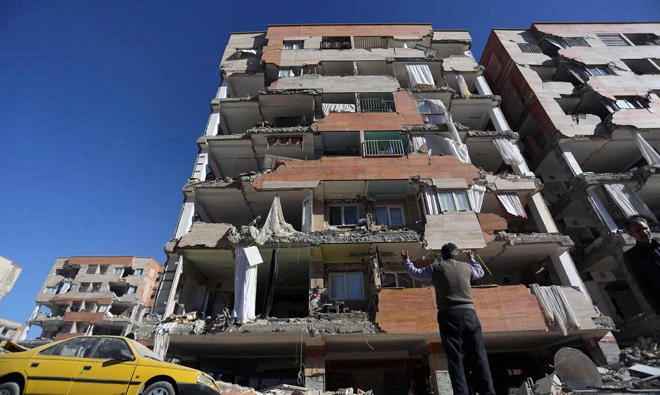 A man reacts as he looks at a damaged building in Sarpol-e Zahab county in Kermanshah, Iran on November 13, 2017. (REUTERS)