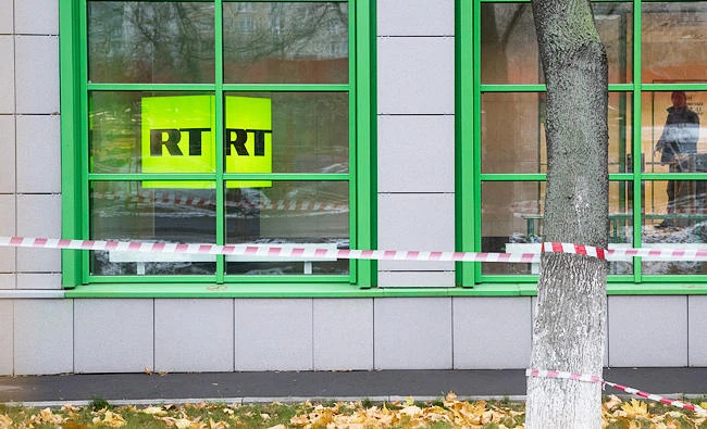 In this Oct. 27, 2017, photo, Russian state-owned television station RT logo is seen at the window of the company's office in Moscow, Russia. (AP)