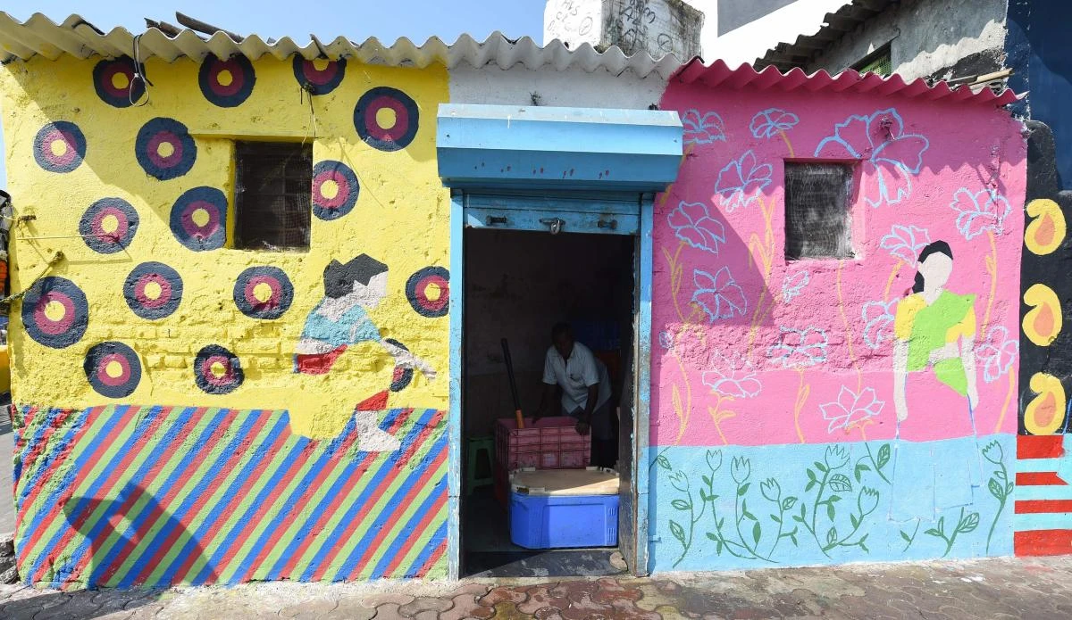 This photo taken on November 9, 2017 shows a fisherman packing crates of fish with ice at his shop with the walls painted for the St+art Festival at Sassoon Dock, one of the oldest fishing docks in Mumbai. (AFP)